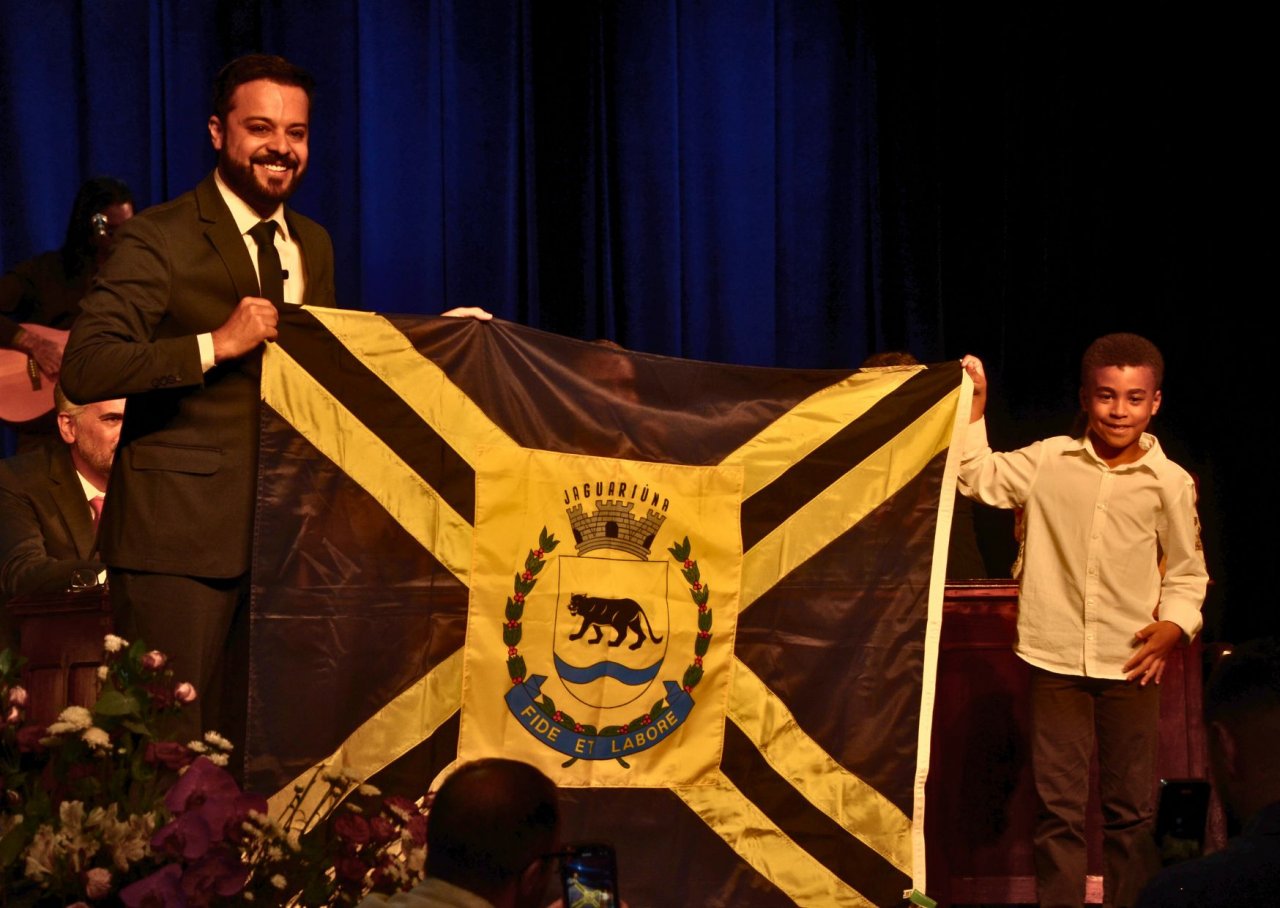 Momento da posse com o filho e a bandeira de Jaguarina (Foto Gislaine Mathias)