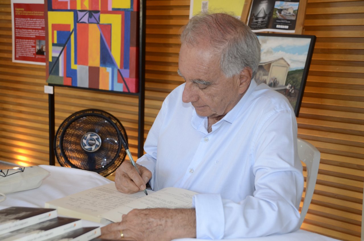 Tomaz autografando os livros (Foto Gislaine Mathias)