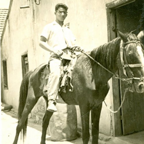 Rubens Frazato a cavalo, em frente da porta da beneficiadora de arroz e do moinho de fubá, do seu pai João, na década de 1940 (Acervo Casa da Memória Padre Gomes) 